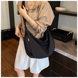 Detailed view of black nylon hobo bag showing large capacity and soft texture on a model