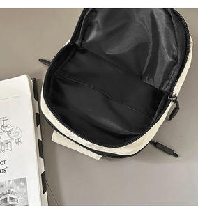 Vista interior con forro negro y compartimento de almacenamiento del bolso bandolera beige