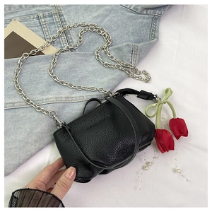 Détail du sac seau en cuir grainé noir avec chaîne argentée et breloque tulipe