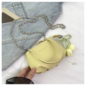 Détail du sac seau jaune en cuir grainé avec chaîne argentée et breloque tulipe
