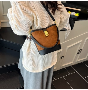 Détails du motif matelassé et fermoir doré sur sac seau rétro marron et bandoulière