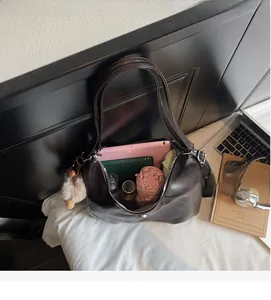 Interno spazioso della borsa tote marrone scuro con tablet, taccuino, borraccia e ombrello