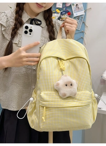 Détail d'un sac à dos en toile à carreaux jaunes avec cordon et breloque étoile