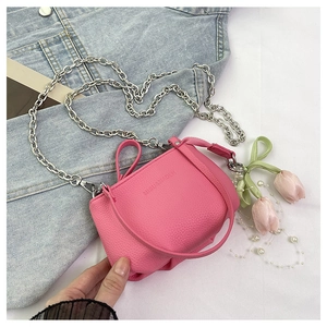 Gros plan du sac seau rose en cuir grainé avec chaîne argentée et breloque tulipe