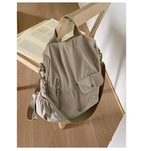 Detail of khaki nylon travel backpack showing side drawstring pocket and durable fabric