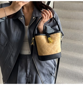 Sac seau matelassé en daim fauve avec bordure en cuir porté en bandoulière