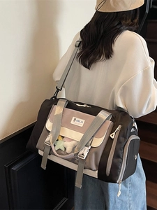 Grande borsa da viaggio patchwork a tre colori con tracolla indossata da un modello