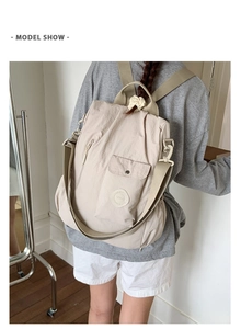 Model wearing a beige nylon convertible backpack with front pocket and SOAN logo
