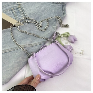 Gros plan du sac en cuir lilas avec chaîne argentée et pendentif fleur en perles