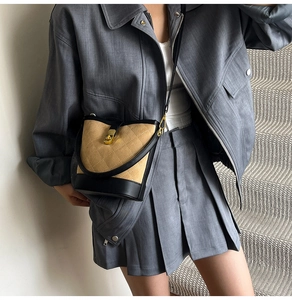 Détail du sac seau matelassé avec fermoir doré tournant sur cuir bicolore beige et noir