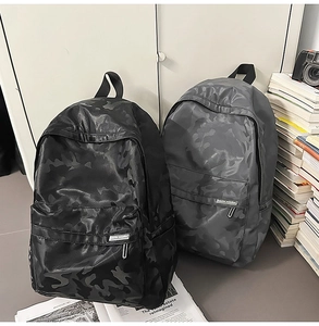 Detail of gray and black camouflage backpacks with waterproof fabric in a study setting