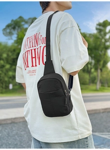 Foto de modelo en exterior de un bolso bandolera negro minimalista de nailon