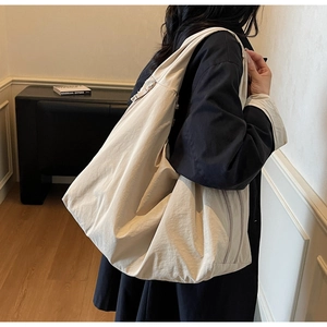 Detail of oatmeal canvas tote bag showing the textured fabric and long zipper closure