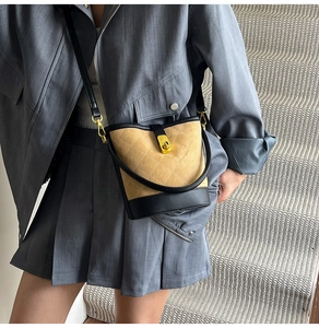 Détail du sac seau matelassé en daim kaki avec finitions en cuir noir et fermoir doré