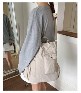 Detail of light beige nylon backpack with multiple functional pockets and durable handles