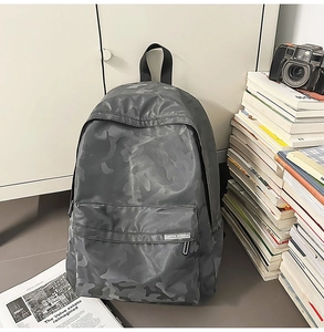 Close-up of grey camo backpack with leather-texture fabric and spacious front pocket