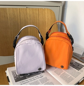 Detalle de mini bolsos bandolera de nailon en violeta y naranja con cremallera doble
