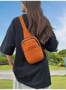 Foto exterior de un bolso bandolera de nailon naranja con tela resistente al agua