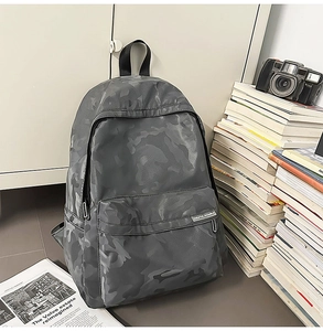 Macro view of water-resistant dark grey camouflage backpack with multi-pocket design