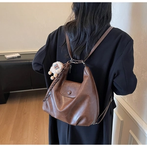 Dettaglio della borsa tote in pelle PU marrone con un simpatico ciondolo a pecora bianca