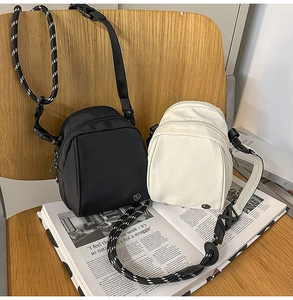 Minibolsos bandolera de nailon en negro y crema con doble cremallera y correa de cuerda trenzada