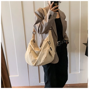 Detail of off-white hobo bag with wide shoulder strap and matching small pouch accessory