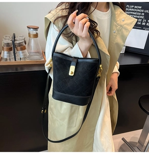 Détail du sac seau noir matelassé avec fermoir doré et bandoulière réglable