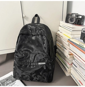 Detail of waterproof camouflage backpack featuring side mesh pocket and smooth zipper closure