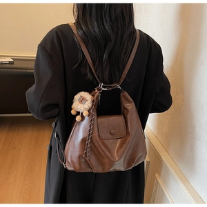 Dettaglio della borsa tote in pelle PU marrone scuro con morbida trama e ciondolo