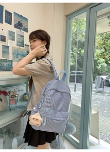 Gros plan d'un sac à dos à carreaux bleus et blancs avec un charmant pendentif étoile