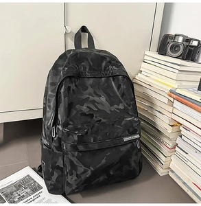 Close-up of black camo print backpack with waterproof texture and front zipper pocket