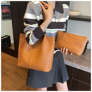 Detail of woven leather tote and matching pouch set in elegant caramel brown finish