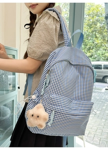 Détail du sac à dos en toile à carreaux bleus avec un joli porte-clé étoile peluche