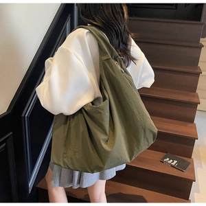 Close-up of olive green oversized canvas tote bag with soft texture and wide shoulder strap