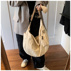 Detail of large off-white pleated shoulder bag with attached matching small pouch