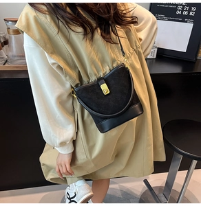 Détails du sac seau noir matelassé avec fermoir rotatif doré et mélange de cuir chic