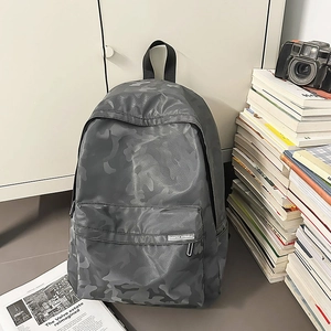 Detail of grey camo waterproof backpack with front zipper pocket and fabric label