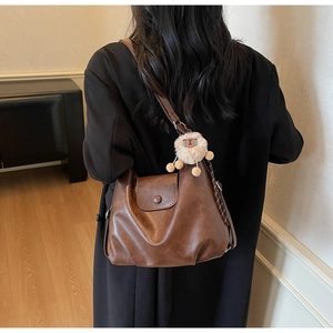 Vista posteriore della borsa tote marrone vintage con un dolce ciondolo a pecora