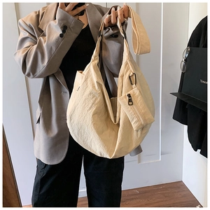 Detailed view of beige slouchy tote bag with textured fabric and small detachable pouch