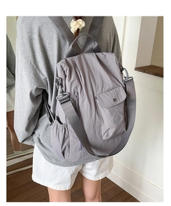 Detail of light grey waterproof nylon backpack with side pockets and padded straps