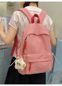 Détail du sac à dos vichy rouge montrant le pendentif étoile et les bretelles larges
