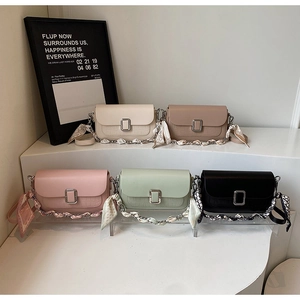 Detail of five croc-embossed crossbody bags with silk scarf wrapped chain straps