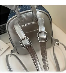Detail of adjustable silver leather straps and denim patchwork on this retro backpack