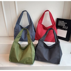 Vue détaillée de sacs fourre-tout en toile à motif à carreaux en plusieurs couleurs vives