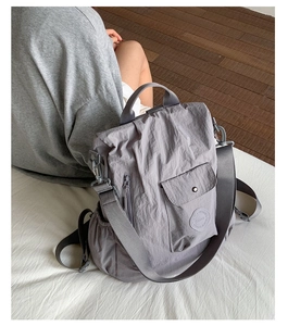 Detailed view of gray multifunctional nylon travel backpack shown on a person