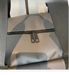 Close-up of smooth dual zippers and durable camo fabric on a fitness bag