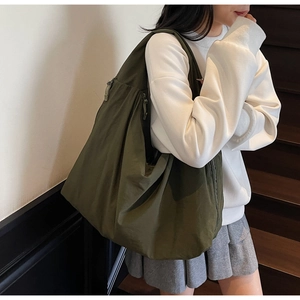 Detail view of large olive green canvas tote bag showing textured fabric and side zipper