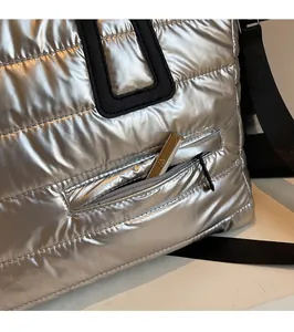 Détail du sac cabas matelassé argenté avec poche zippée avant et rangement utile