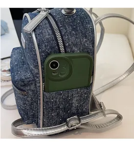 Close-up of side pocket on blue polka dot denim backpack with silver leather trim