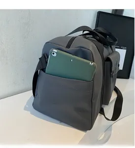 Detail of grey gym bag side pocket showing storage capacity with a tablet inside